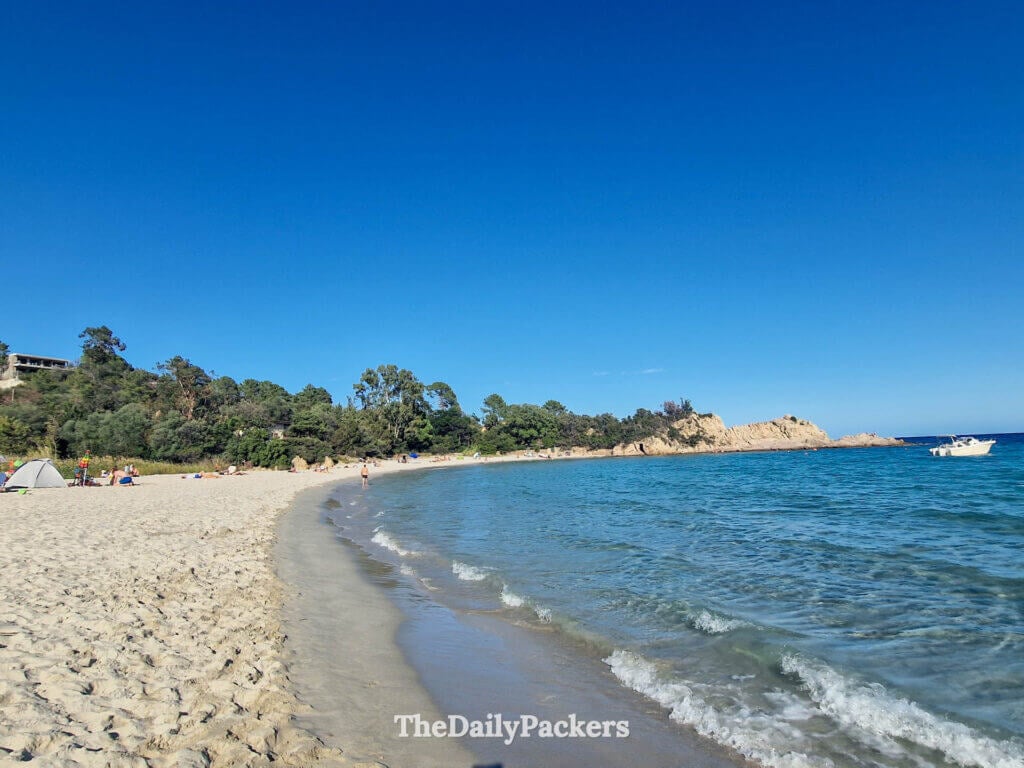 Golden sand and turquoise water at the scenic, crescent-shaped Canella Beach in Corsica.