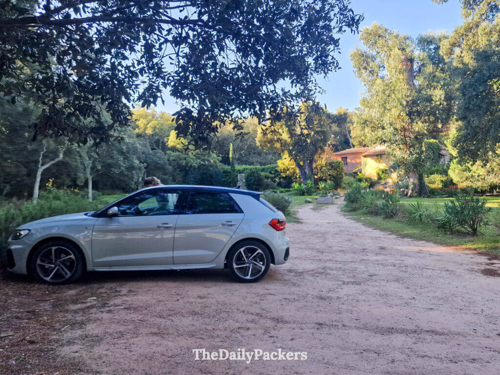 A grey rental car parked in the designated gravel driveway at U Barraconu guesthouse, Corsica.