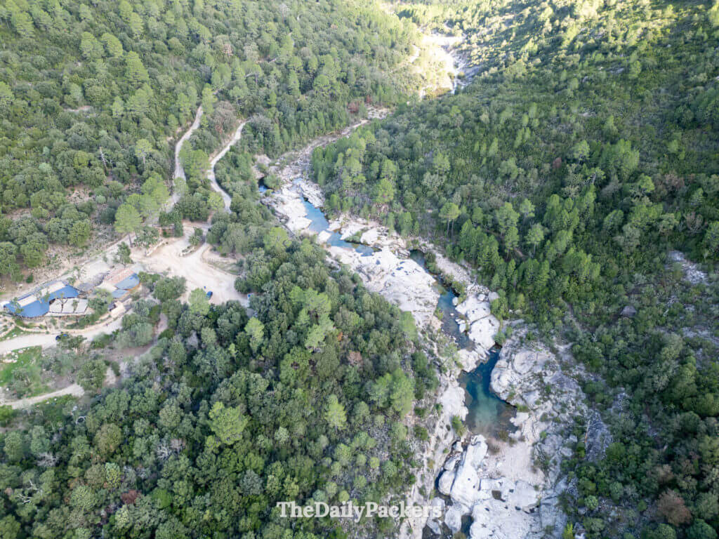 Aerial view of clear green river channels cutting through large granite rocks in the Cavu Valley.