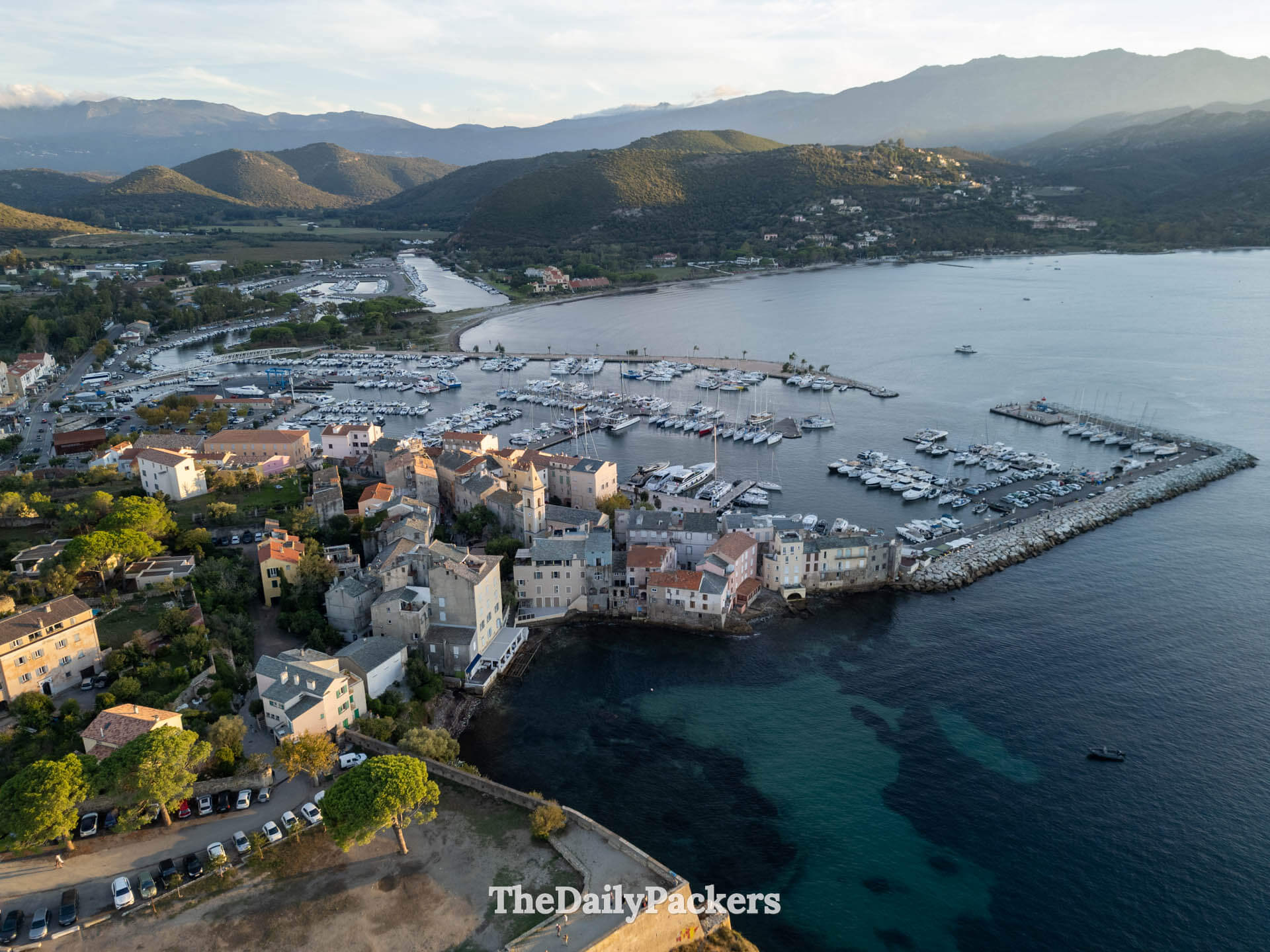Un coucher de soleil doré éclatant sur les eaux calmes de la mer et les montagnes lointaines à Saint-Florent, en Corse.