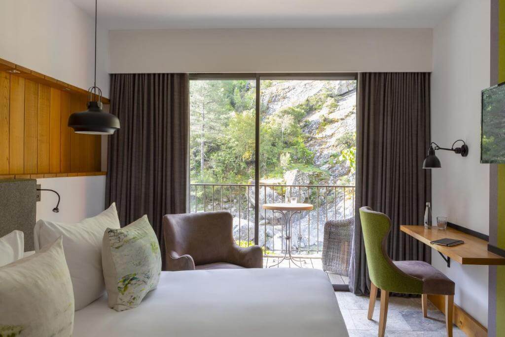 Modern and cozy hotel room at Dominique Colonna in Corte with wooden accents and a view of the surrounding greenery.