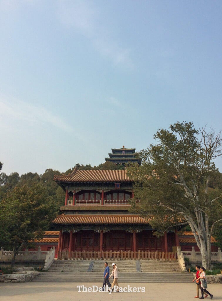 Grand pavillon d’entrée du parc Jingshan à Pékin, avec des toits dorés et la tour Wanchun à l’arrière-plan