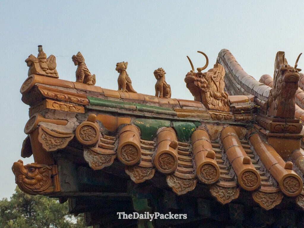 Gros plan sur des figurines de gardiens mythiques sur une arête de toit en céramique émaillée au Palais d’Été de Pékin