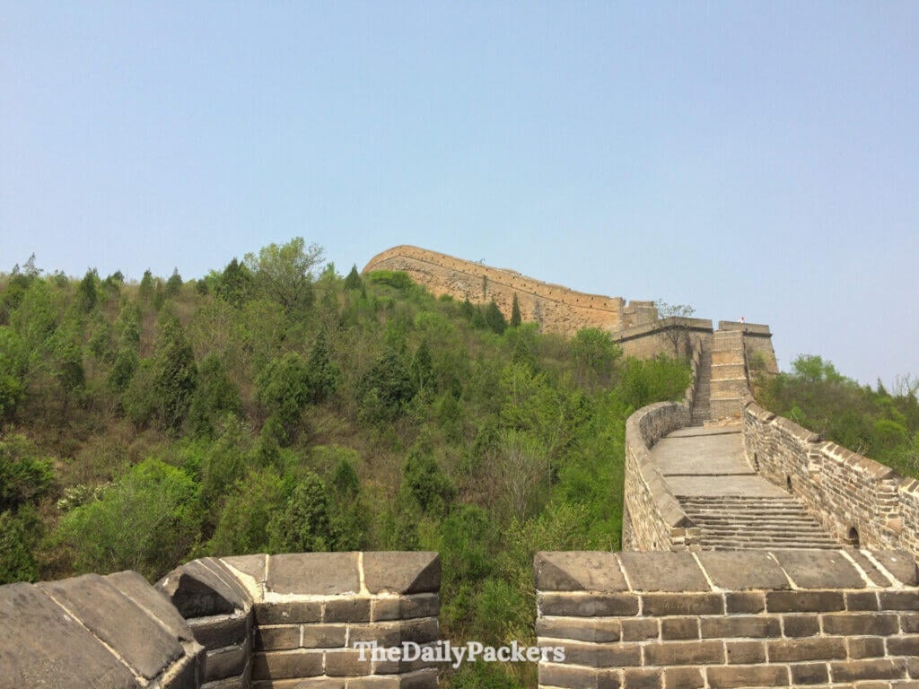Steep stone steps of Jinshanling Great Wall climbing a forested ridge, China