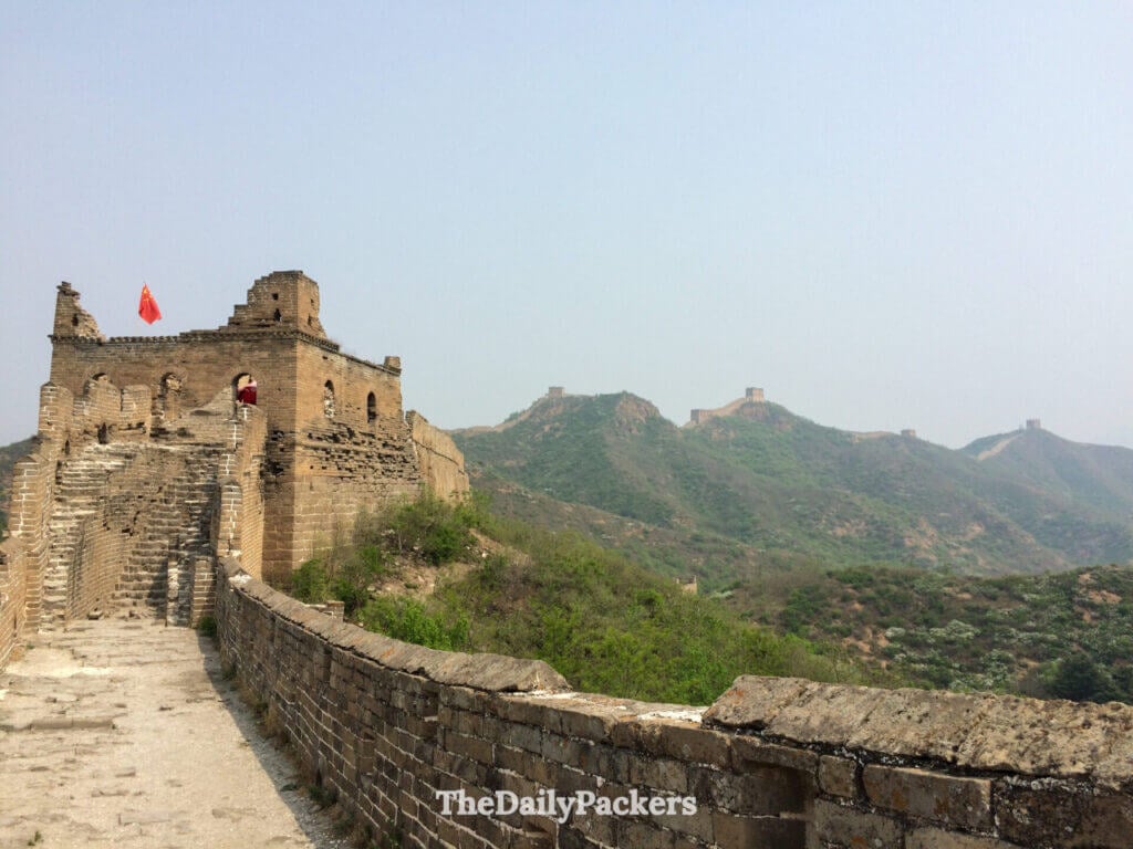 Tour de guet en détérioration avec drapeau chinois sur une section non restaurée de la Grande Muraille de Jinshanling, Hebei