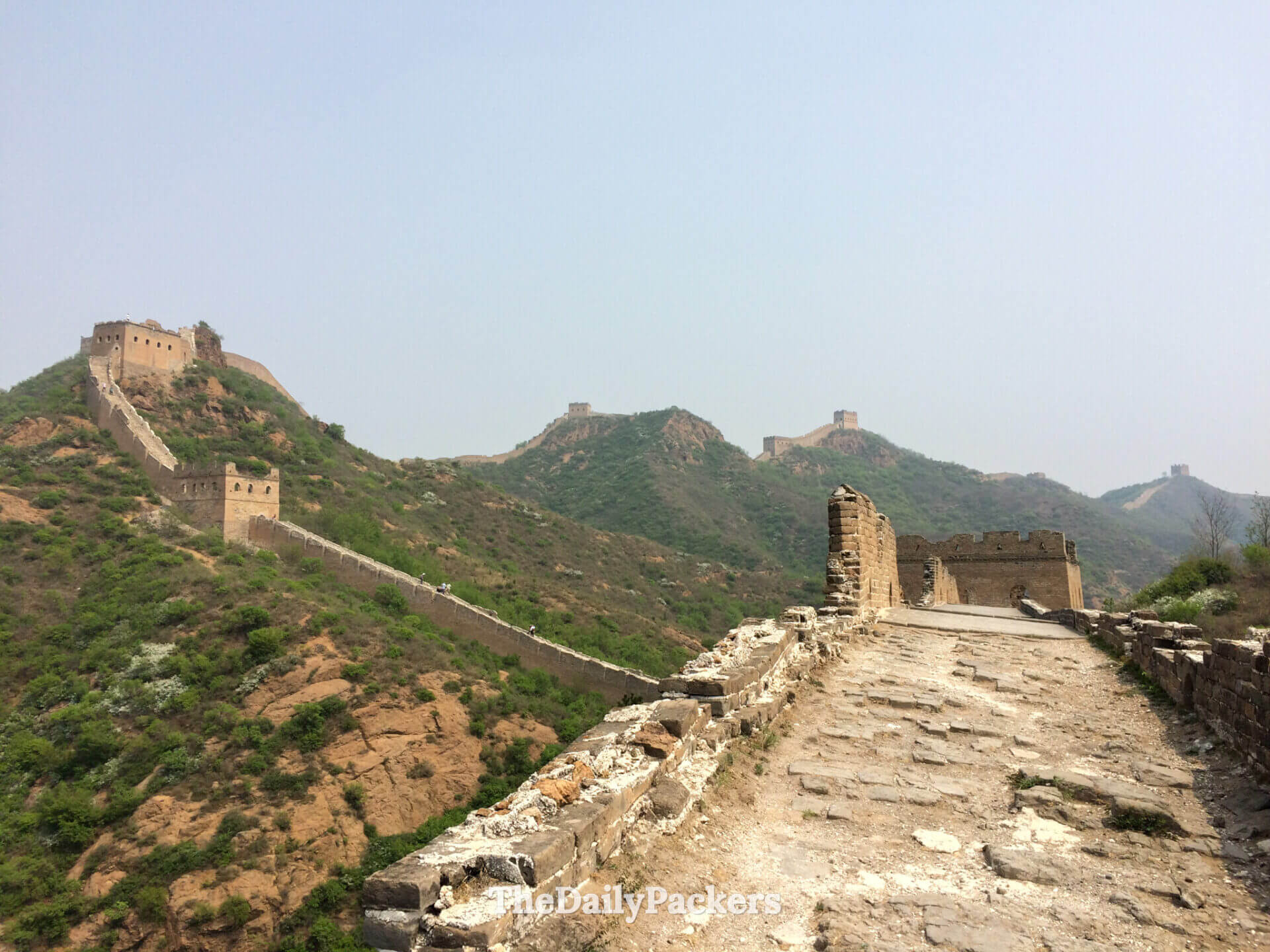 Eroded walkway and partially collapsed watchtower on the wild Jinshanling Great Wall, China