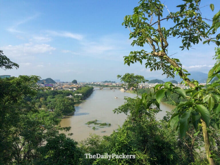 Li River winds past Guilin's skyline and karst peaks, seen from Xiangshan Park hilltop.