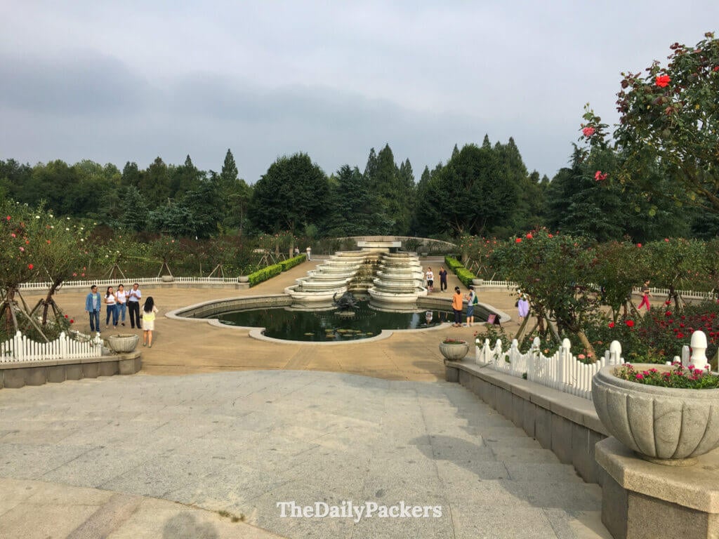 Fontaine en pierre à plusieurs niveaux entourée de roseraies dans un parterre de parc à Hangzhou, Chine