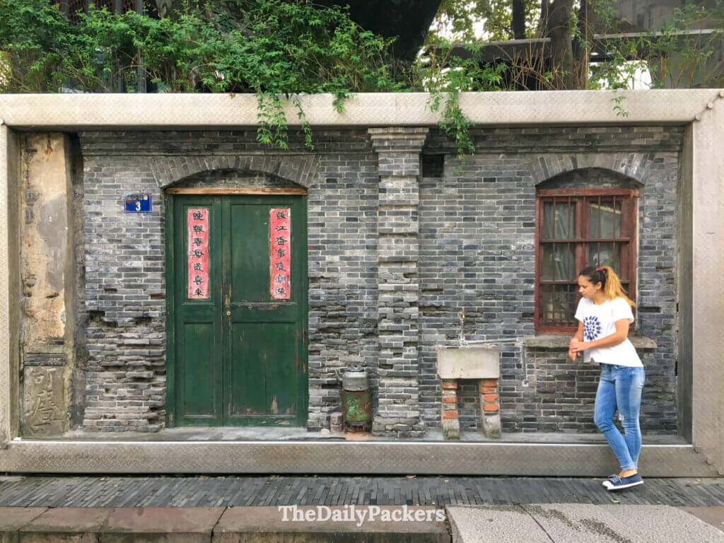 Femme à côté d’une fresque de street art en trompe-l’œil représentant une vieille maison chinoise en briques, Hangzhou