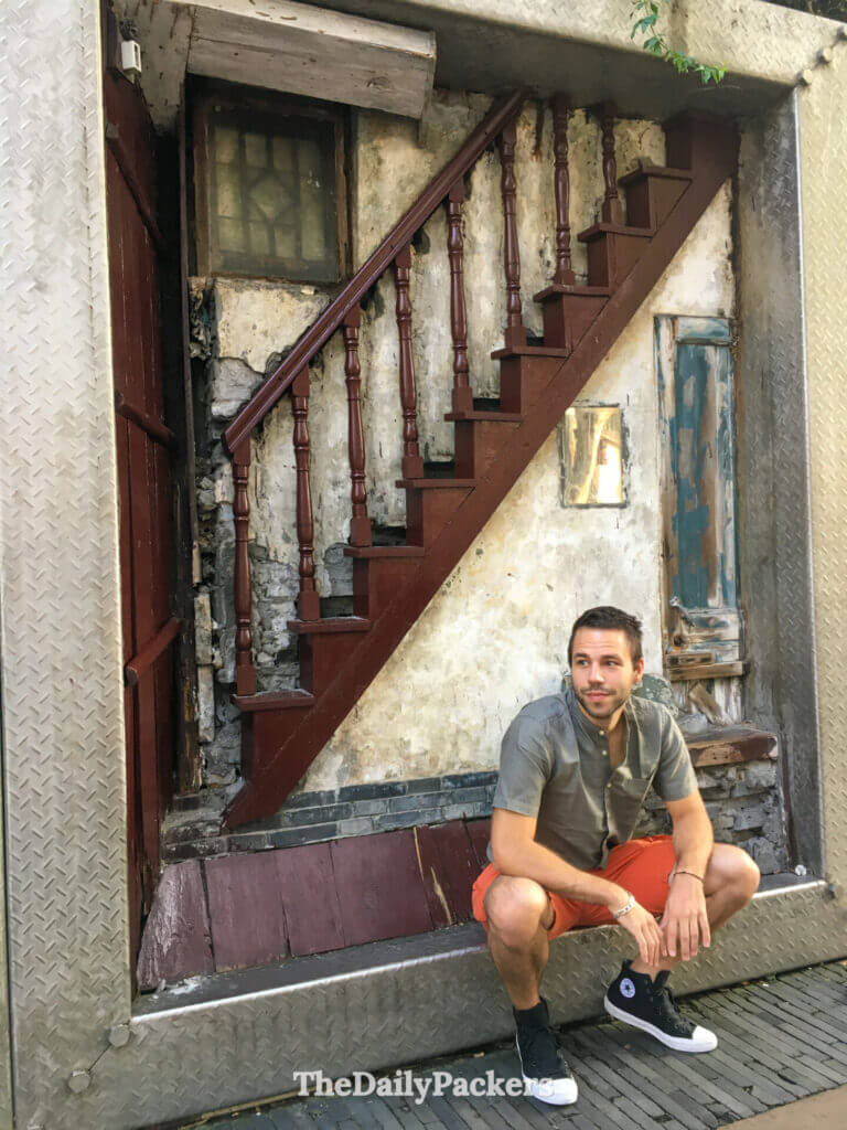 Homme posant devant une installation de street art 3D représentant la façade d’un escalier en ruine, Hangzhou