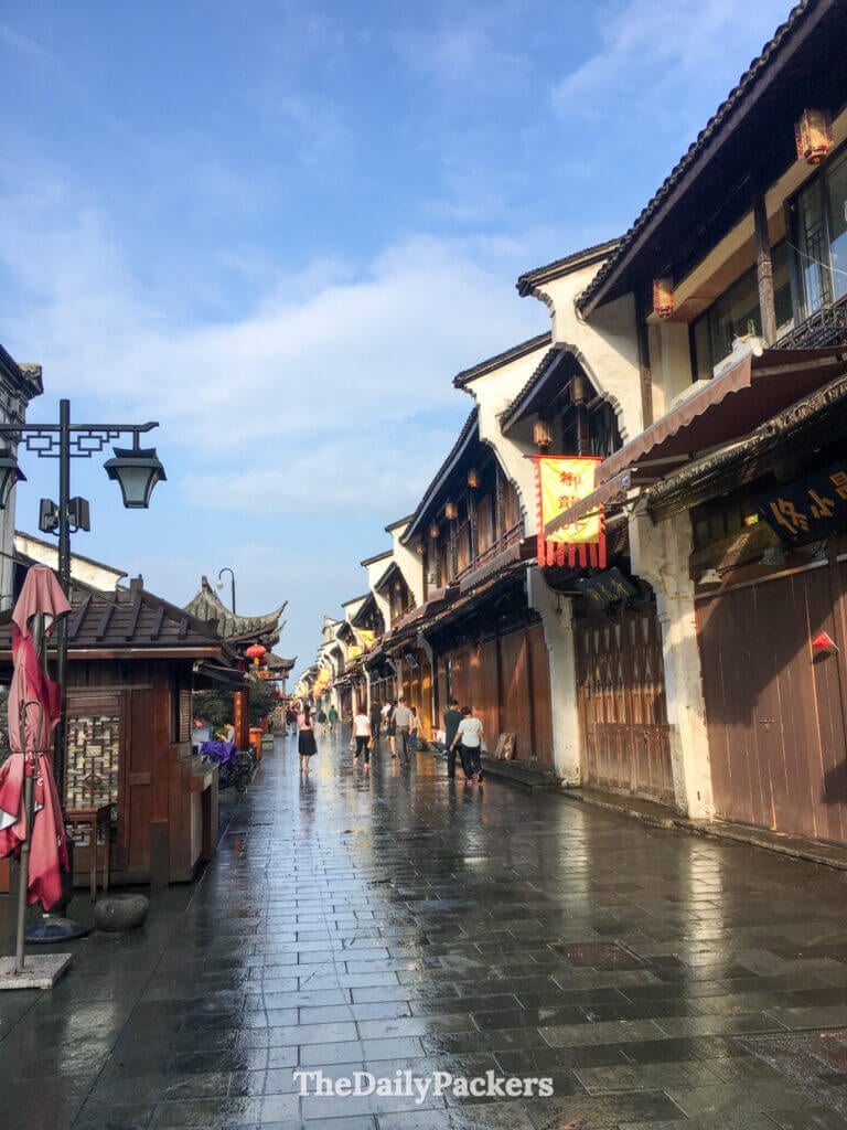 Ruelle pavée de galets luisants de pluie, bordée d’échoppes traditionnelles en bois sur la rue Hefang, Hangzhou