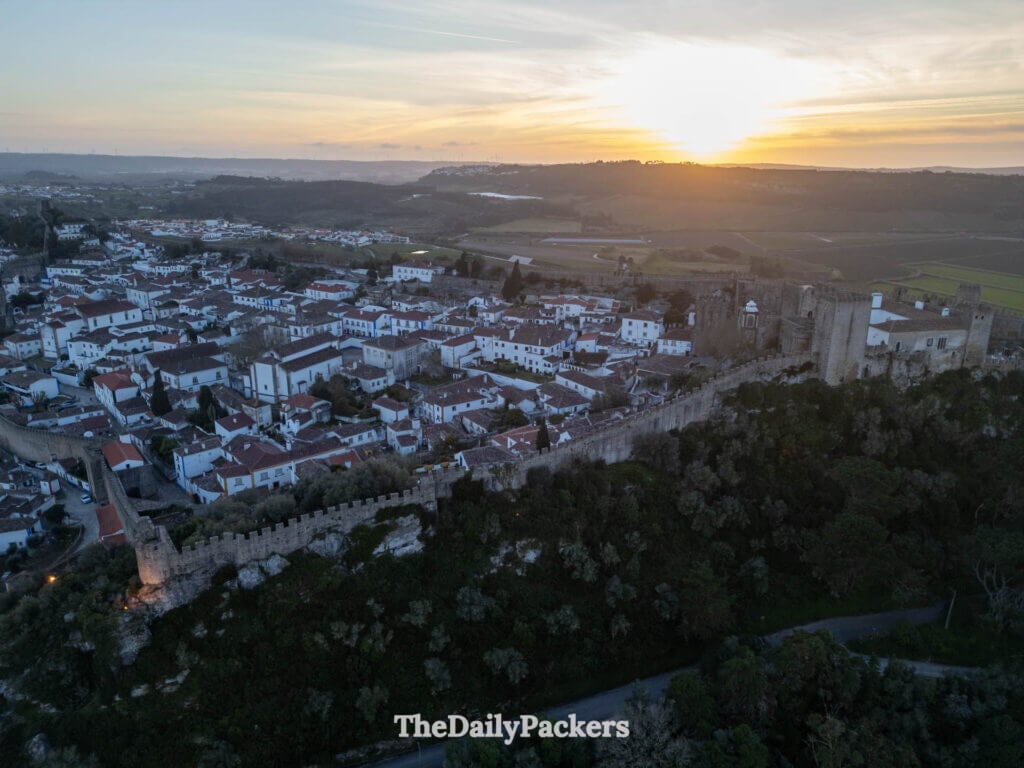 Aerial view of the medieval walled town of Obidos, Portugal, at sunset.