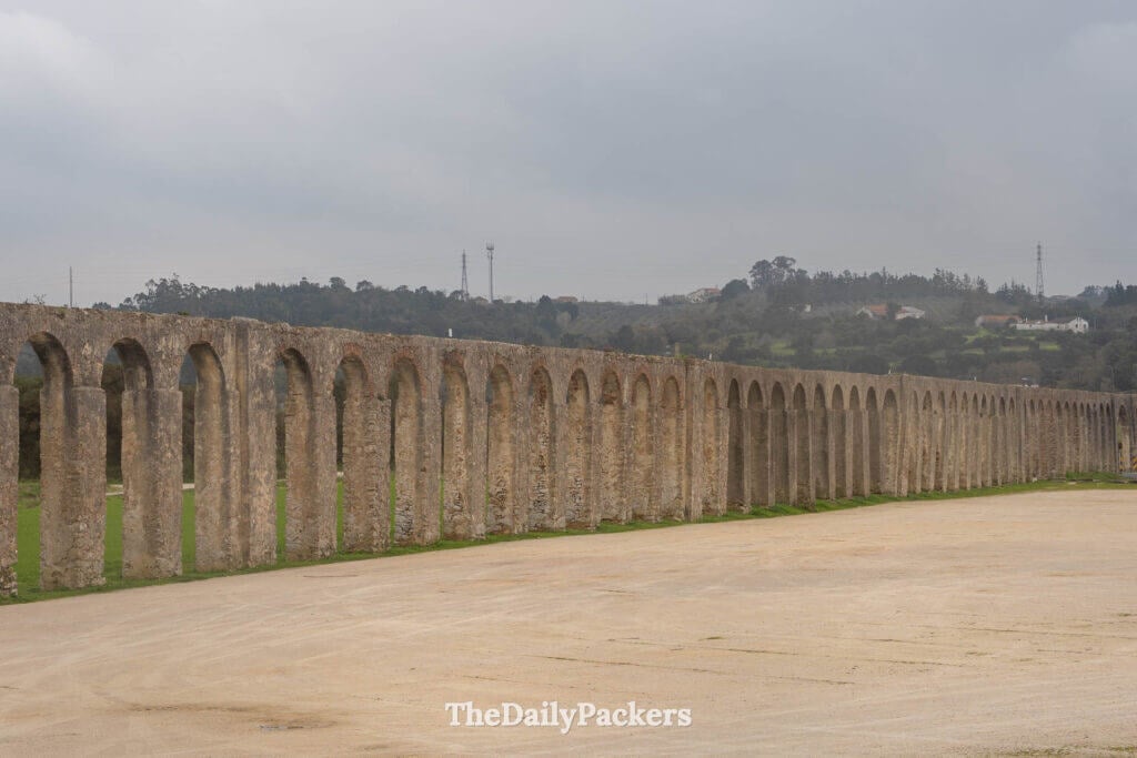 The long, historic stone arches of the Usseira Aqueduct just outside Óbidos.