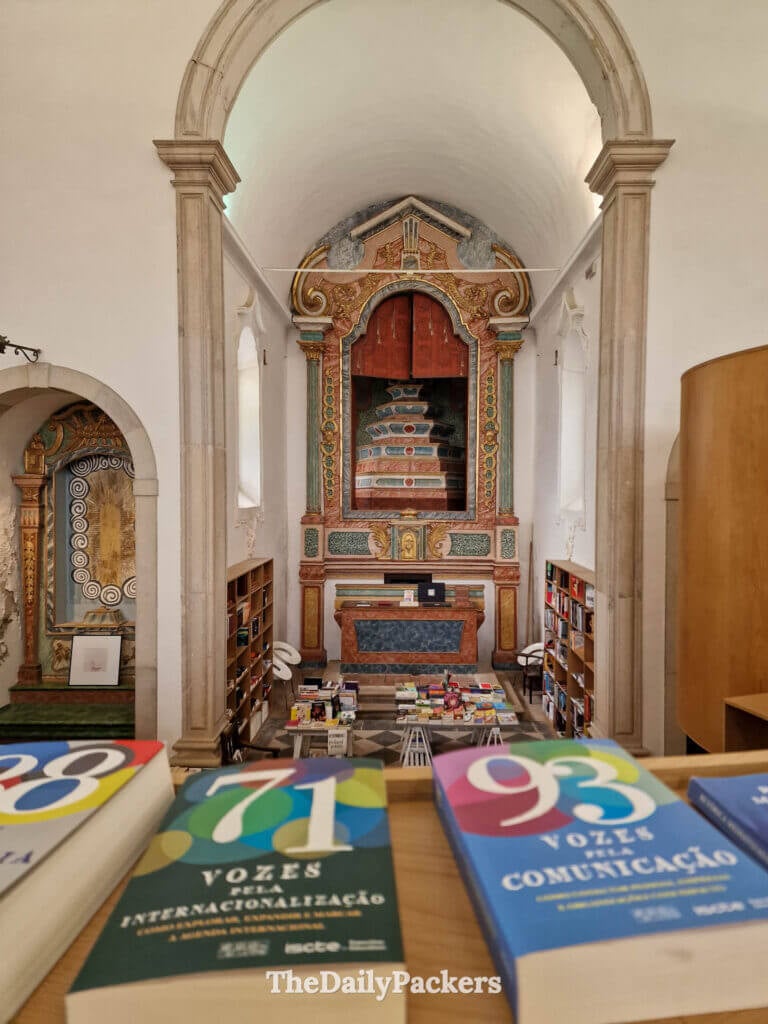 Interior view of the unique Livraria de Santiago church bookshop filled with shelves of books.