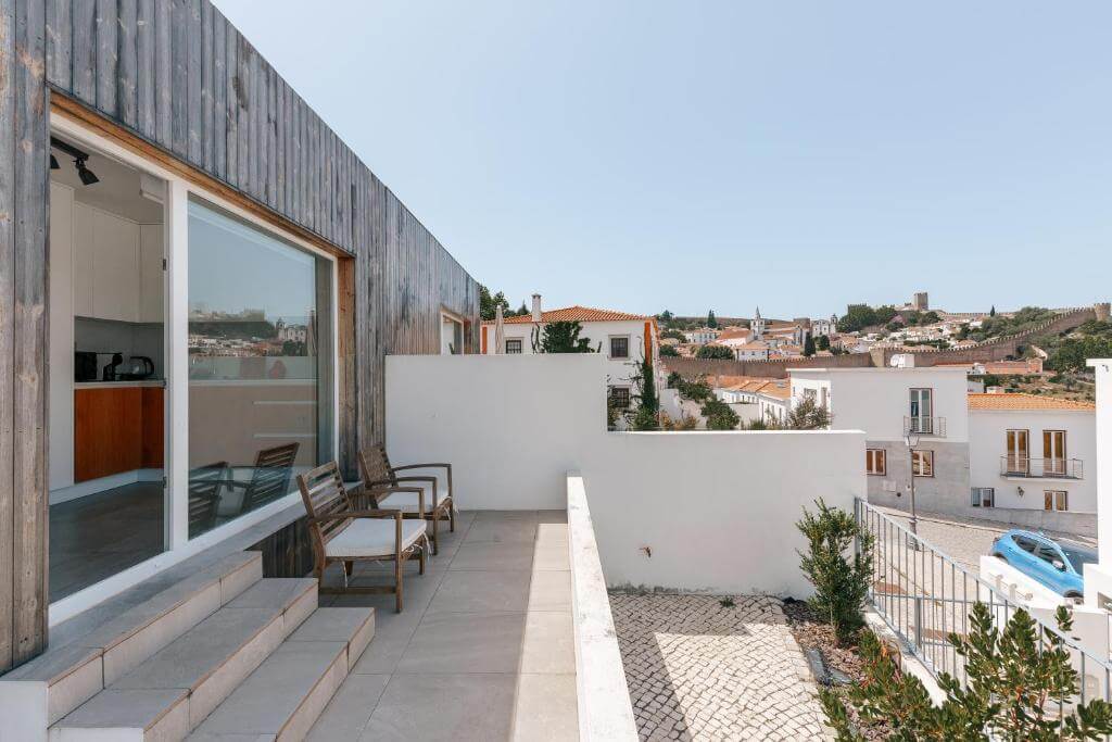 Modern terrace at Retiro do Castelo showing panoramic views over the historic town of Óbidos.