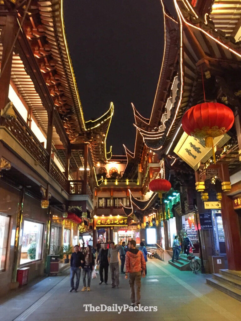 Ruelle piétonne étroite avec lanternes rouges et toits de pagode illuminés dans la vieille rue du jardin Yu, Shanghai