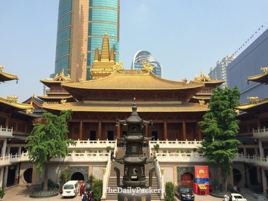 Salle principale au toit doré du temple bouddhiste Jing'an contrastant avec les gratte-ciel modernes derrière, Shanghai