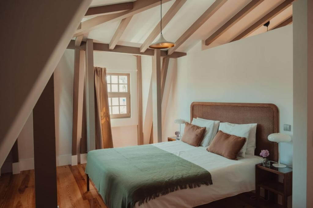 Cozy boutique bedroom with wooden beams and a double bed at a hotel in Sintra.