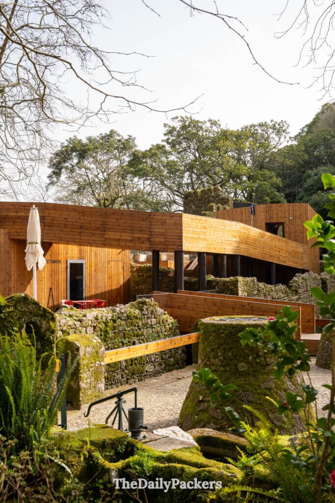 A modern wooden cafe structure sits among the historic stone ruins at the Moorish Castle.