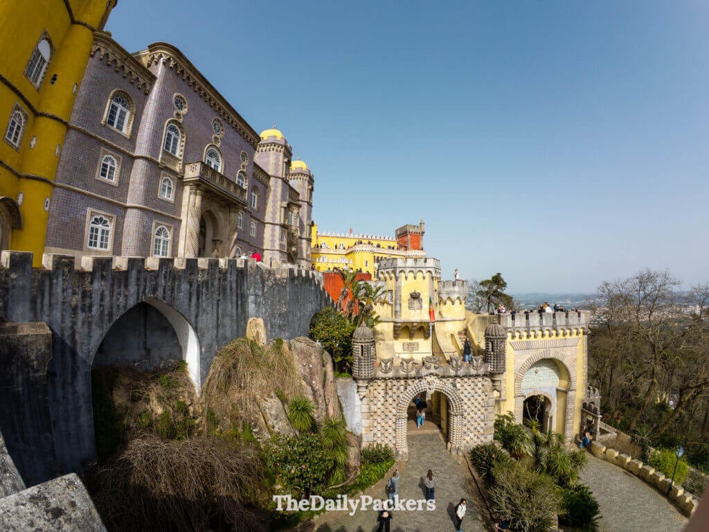 Looking down at the stone archways and entry gates of Pena Palace from above.