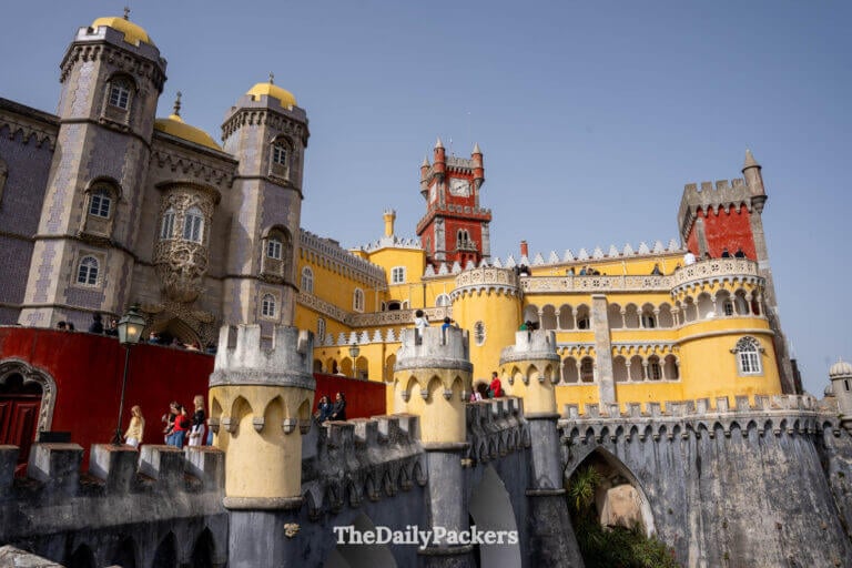 Vibrant yellow terraces, Manueline towers, and red clock tower architecture at Pena Palace.