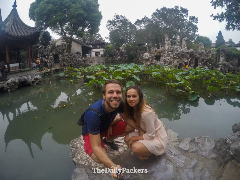 Couple sur un rocher à côté de l’étang aux lotus avec des formations de pierres de Taihu au Jardin du Bosquet du Lion