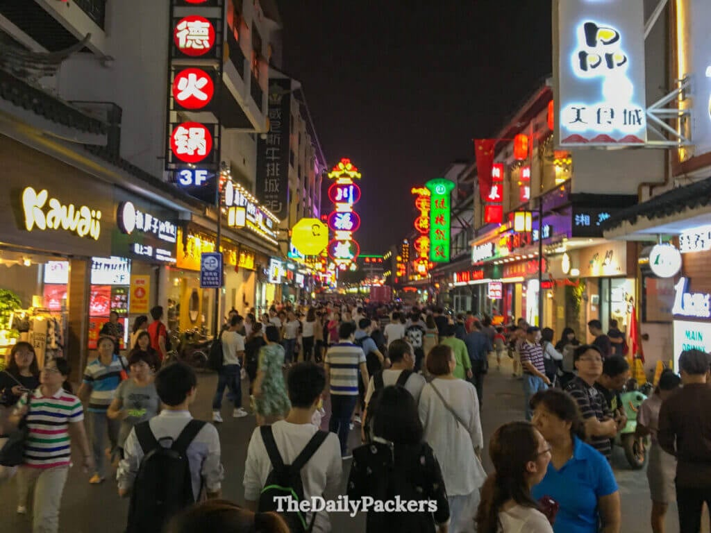 Rue piétonne animée, éclairée au néon la nuit, dans le centre-ville vibrant de Suzhou