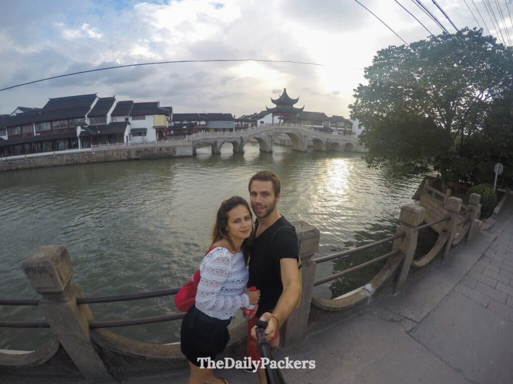 Couple posant au coucher du soleil avec le pont pagode voûté de Panmen enjambant le canal extérieur de Suzhou