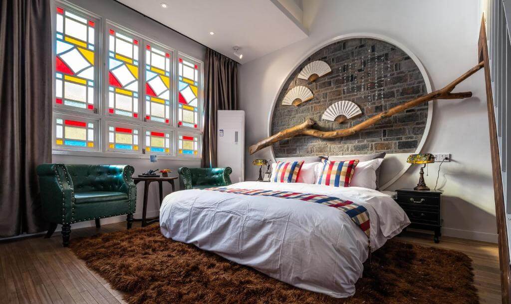 Chambre boutique artistique avec vitraux et tête de lit en porte de lune au Houlishenghuo Guesthouse Suzhou