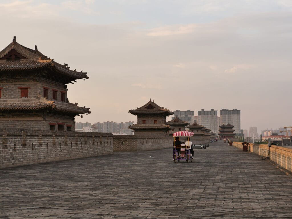 Des cyclistes profitent d’une balade le long des remparts historiques de Xi’an au coucher du soleil.