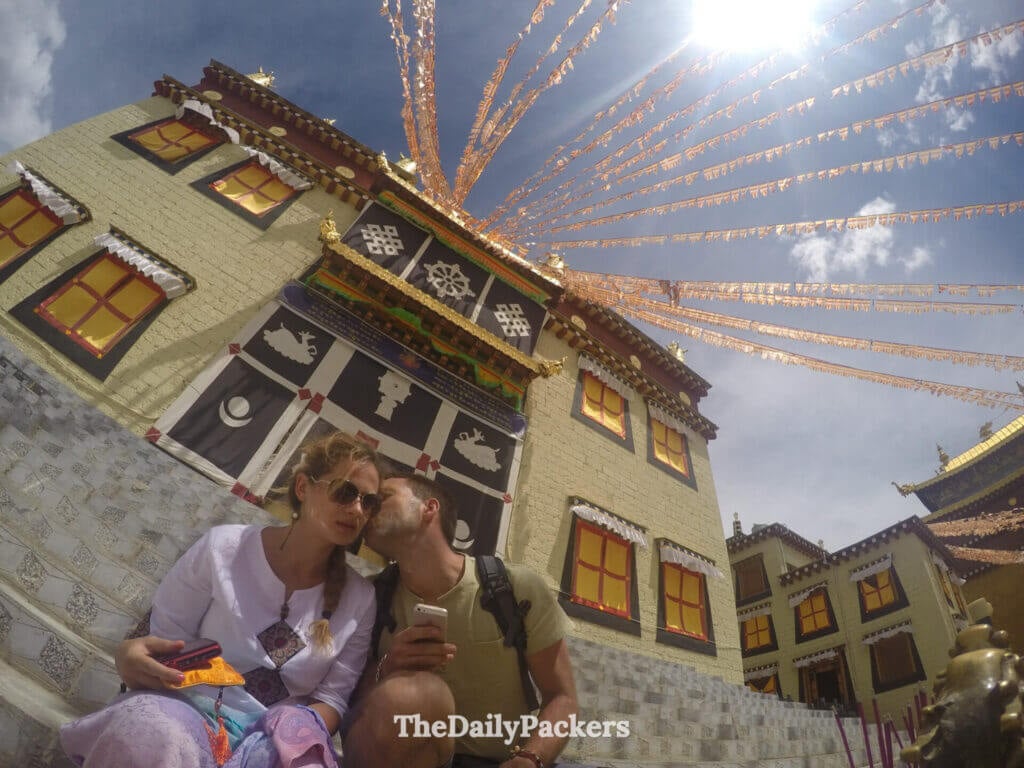 Des voyageurs posent pour un selfie sous des drapeaux de prière au monastère de Songzanlin, à Shangri-La.