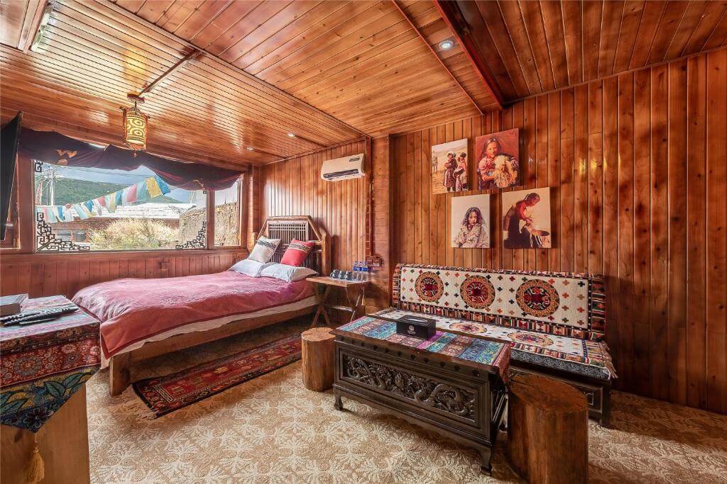 Chambre chaleureuse lambrissée de bois avec décor tibétain au Yi's Hostel, Shangri-La.