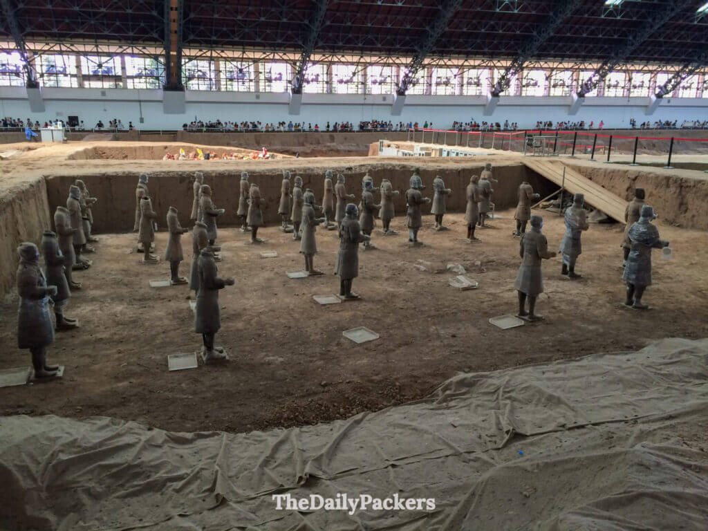 Figurines de terre cuite partiellement enveloppées lors de fouilles archéologiques en cours